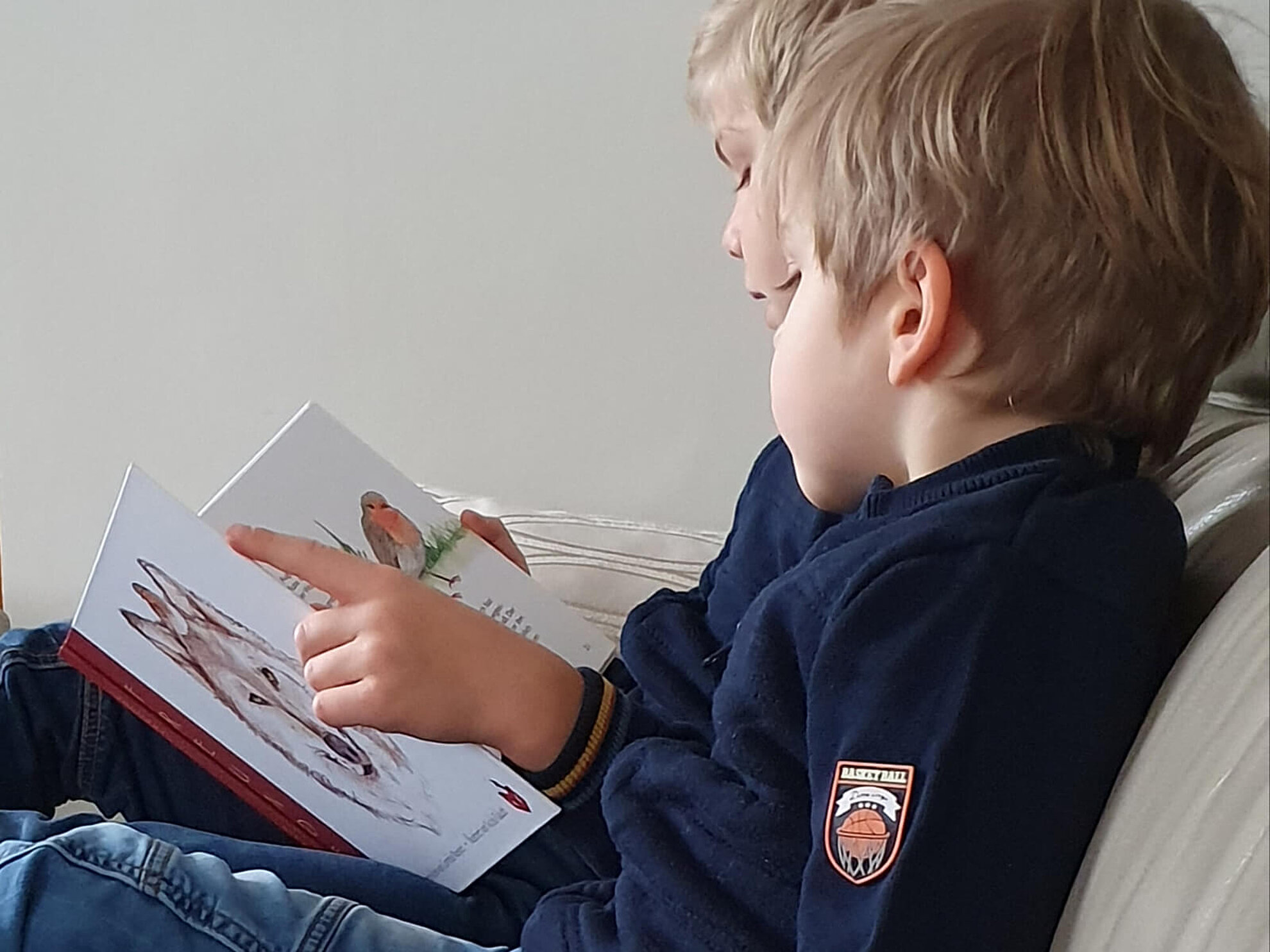 Zwei Kinder lesen gemeinsam das Buch «Freunde»
